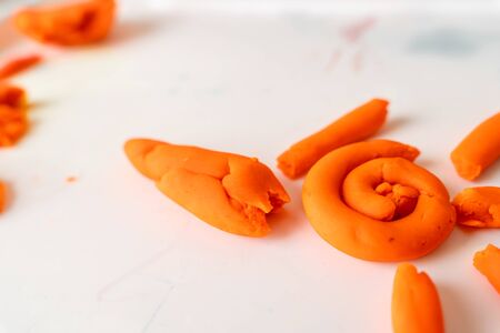 Little toddler plays play dough. Modeling orange sun. Creativity imagination skill
