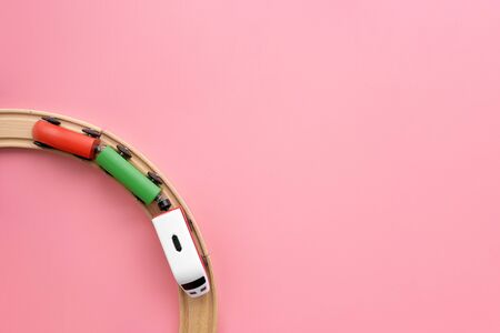 Top view of circle wooden railway and train on pink background