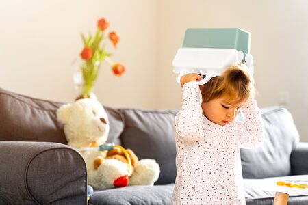 Bad behaviour toddler girl playing strange game. living roomの写真素材