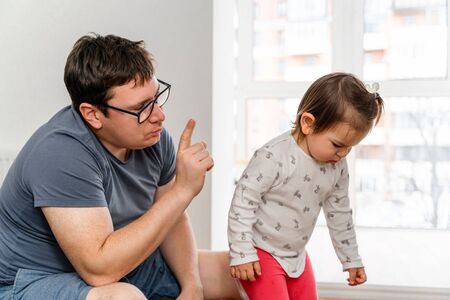 Father punishing his daughter for her bad behaviour. Strict parenting concept