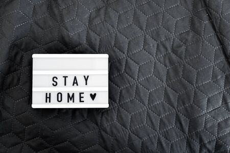 Lightbox with Stay home text on wooden background. Top view flat lay Covid-19 quoteの写真素材