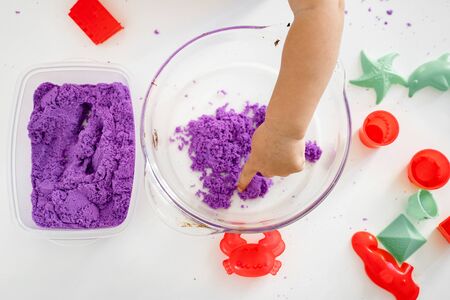 Close up of baby hand playing with kinetic sandの写真素材