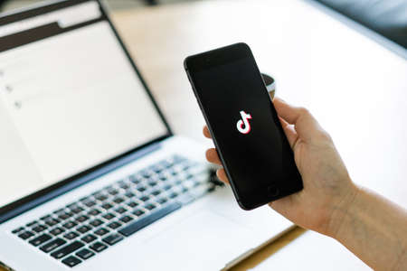 Poltava, Ukraine - June 2020 Phone on the wooden table and with TikTok logo on it.