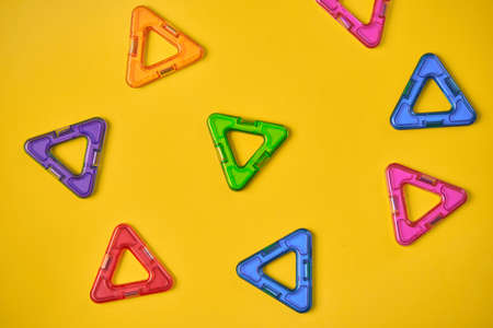 Top view of colorful magnetic building blocks on yellow background