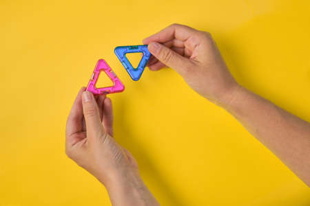 Top view of colorful magnetic building blocks on yellow background