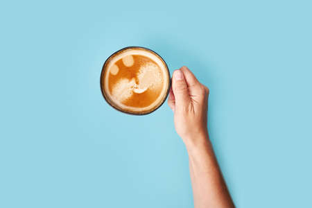 Top view of coffee in cup on blue background. Morning coffee time
