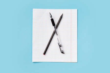 Top view of blank school paper with pen on blue background