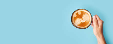 Top view of coffee in cup on blue background. Morning coffee timeの写真素材