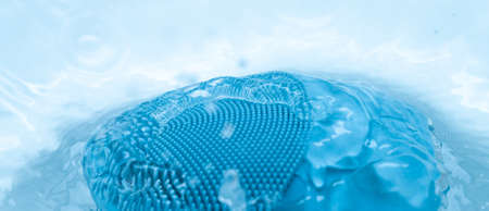 Skin massager in pure water in blue colors. Home wellness concept. Skin care