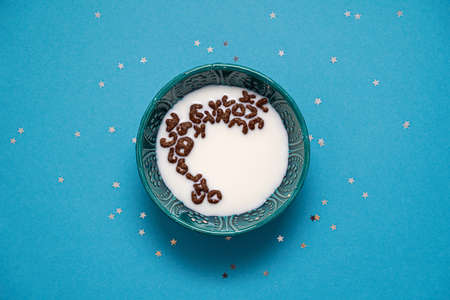Blue background with stars. Bowl with milk and alphabet cocoa cerealsの写真素材