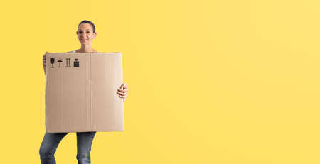Young miillennial woman relocation with huge carton box. Online purchase, delivery person.の写真素材
