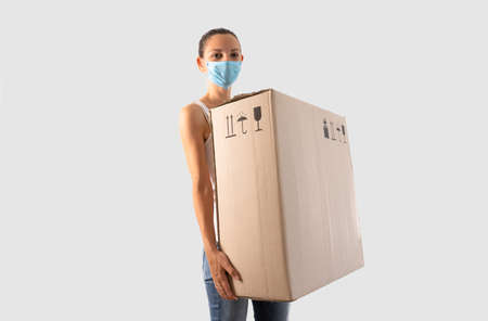 Young miillennial woman relocation with huge carton box. Online purchase, delivery person.の写真素材