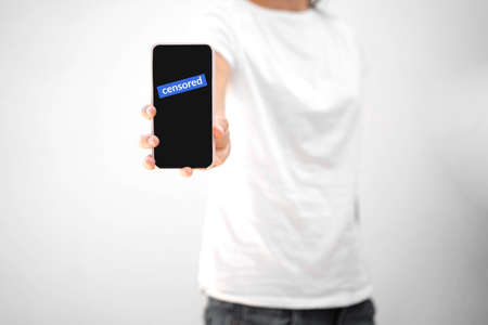 woman with phone and censored text on it. Social media censorship conflict.の写真素材