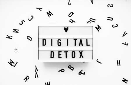 digital detox words on white lightbox. concept of unlpug, technology break.