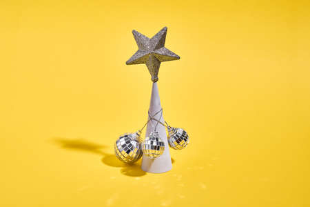 Christmas tree as concrete conus with golden star and disco balls. 90s new year party