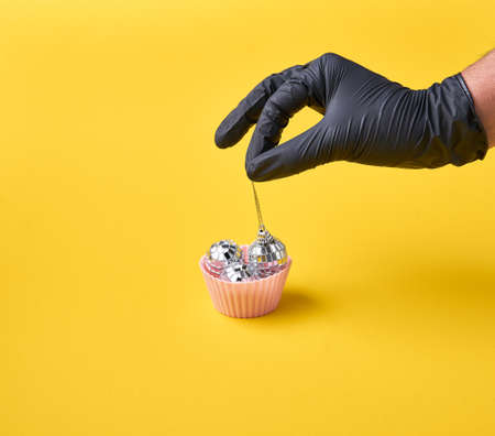 Muffin with disco balls and chef hand in black gloves. Nightlife in retro style.の写真素材