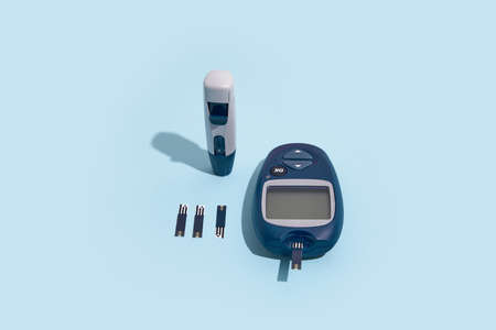 Glucose meter and pen on blue background with shadow, Metabolic syndrome conceptの写真素材