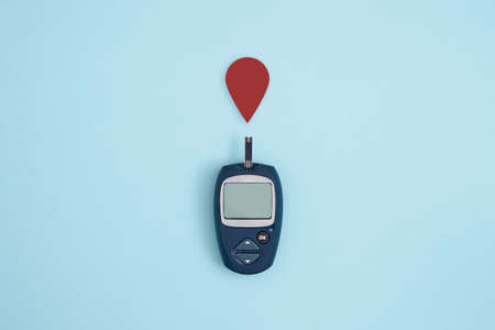 Glucose meter and blood drop on blue background, Metabolic syndrome concept