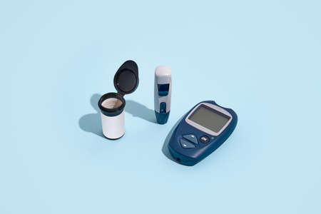 Glucose meter and pen on blue background with shadow, Metabolic syndrome concept