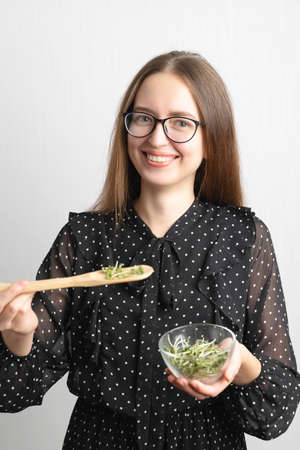 Caucasian young beautiful woman with microgreens salad superfood, healthy lifestyleの写真素材