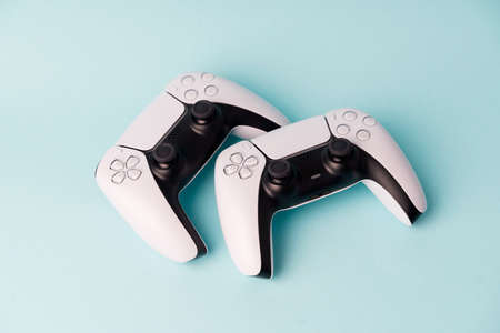 Videogame console wireless gamepad. Blue background. Minimal style. Modern leisure at home. Couple gamersの写真素材