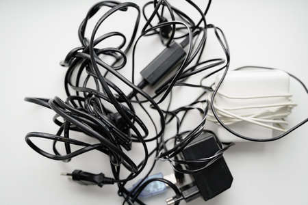 E waste, old cables and green plant. Gadget recycle of tech junk. Environment pollution