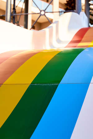 Rainbow multicoloured slide in aqua park in kids playground. Summer time activity outdoors with family. Lgbtq colours of prideの写真素材