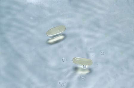 Beauty skin care product. Water drop background. Hyaluronic serum. Vitamin drop pill capsule. Health...