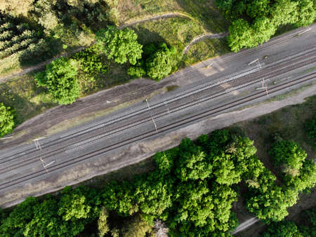 Aerial view of railroad in sunny summer day in forest. Top view of Logistics, trade, shipping ways.の写真素材
