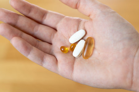 Close up of hand with pills on it. Supplements with omega, vitamin d, magnesium. Medications for...
