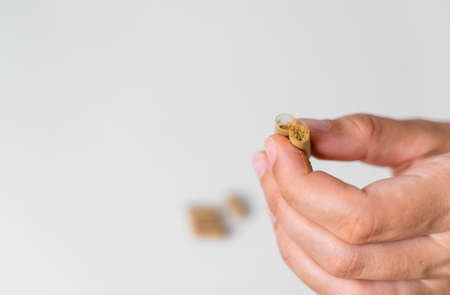 Close up hand with herb capsule on white background. Microdosing concept. Psychedelics therapy....