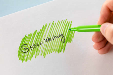 Greenwashing concept. Drawing on paper with text and green marker strokes. Environmental marketing disinformation. Non transparent green sheen.の写真素材