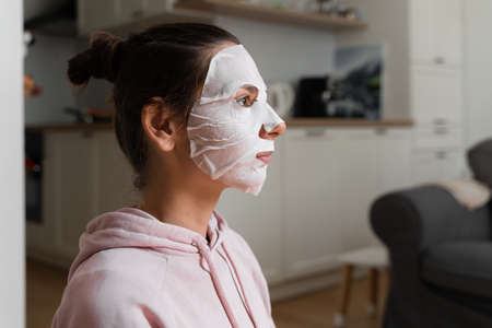 Young woman with beauty mask at home. Snackable wellness concept. Relaxation at home for young mother. Quick face mask for home spa.の写真素材