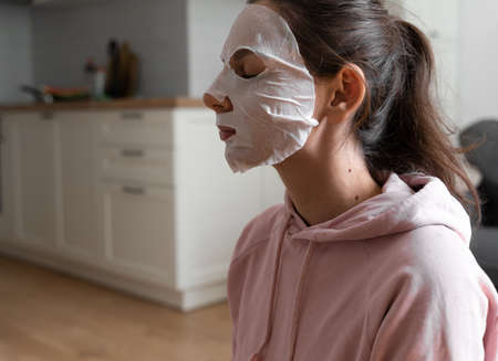Young woman with beauty mask at home. Snackable wellness concept. Relaxation at home for young mother. Quick face mask for home spa.の写真素材