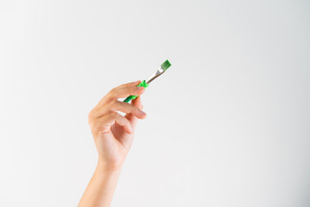 Greenwashing concept. Green pain and brush. Environmental marketing disinformation. Non transparent green sheen.の写真素材