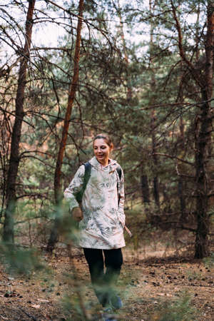 Woman in forest on a sunny day. Pine high trees. Close to nature, mental healing with fresh air. Digital detox, unplugged on nature. survival skillsの写真素材