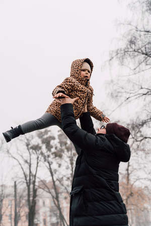 Father playing with child outdoors. Happy parenting, family bond. Toddler preschool girl daughter with father lifting upの写真素材
