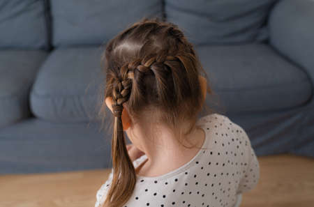 Girl child with hair messy braid at home, hairstyle for kidsの写真素材