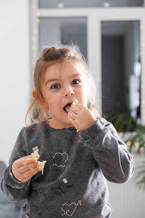 Funny little child girl cooking cookies with dough. Home activities for kids