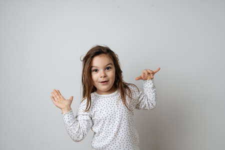 Portrait of pretty caucasian girl in white pyjama in studio white backgroundの写真素材