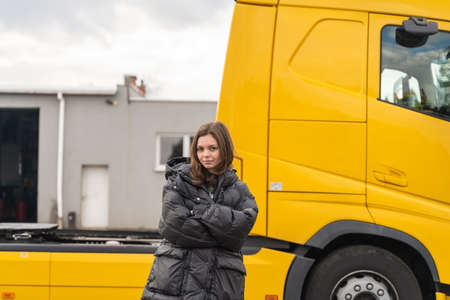 Caucasian young woman driving truck. trucker female worker, transport industry occupation