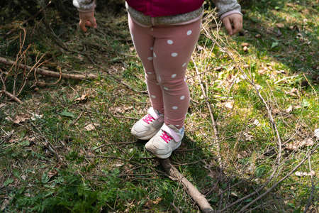 Close up of child girl legs in forest. Hiking with children on nature, outdoors trail for kids....