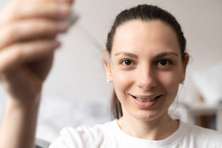 Close up of white woman hand applying oil of essential oil or serum for skin. Self care conceptの写真素材