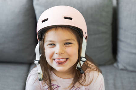 Preschool girl portrait with safety for outdoors activities. Pink helmet and wrist padsの写真素材
