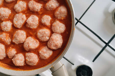 Meatballs cooking process in a pan at home. Beef, chicken and pork meat food recipe in tomato sauceの写真素材