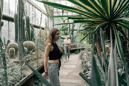 Two woman in a greenhouse full of cactuses. Plant garden for touristsの写真素材