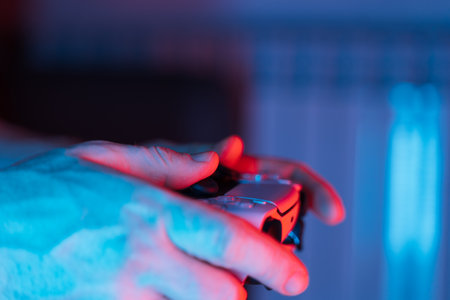 Man hands with game controller in neon light, top view