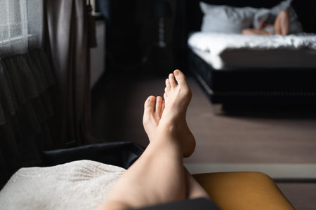 POV legs relaxing on the sofa with child watching cartoons on the background. Mother relax dayの写真素材
