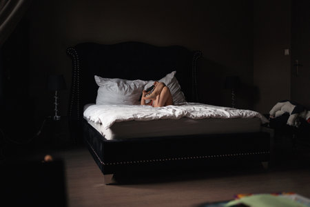 5 years old girl watching cartoons on mobile phone on the bed. royal luxury interiorの写真素材