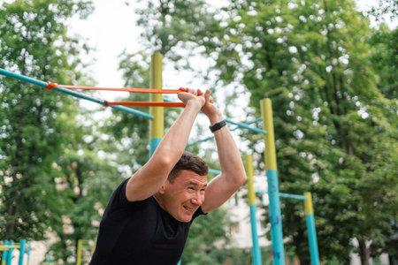 Middle age man doing strength exercises with resistance bands outdoors in parkの写真素材